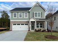 Two-story home with gray siding, brick accents, and a two-car garage at 11834 Rizvan Pl, Covington, GA 30014