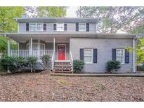 Two-story house with red front door and covered porch at 1507 Hillside Se Dr, Conyers, GA 30094