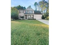 Two-story house with a large front yard, attached garage, and stone accents at 4060 Willowmere Pointe Nw, Kennesaw, GA 30144
