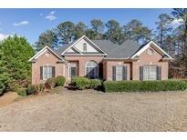 Brick house with a large yard and mature trees at 3680 Windlake Dr, Snellville, GA 30039