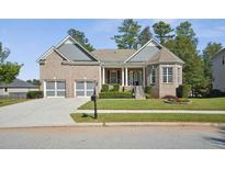 Brick home with gray accents, two-car garage, and landscaped yard at 3502 Maple Hill Rd, Stonecrest, GA 30038