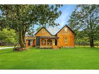 Beautiful Farmhouse Exterior with lush green lawn at 220 Fair St, Loganville, GA 30052