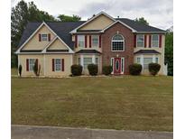 Two-story house with brick and siding, red accents, and a manicured lawn at 300 Redford Trl, Stockbridge, GA 30281