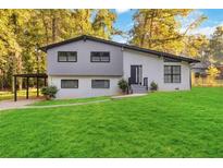 Mid-century modern home with gray and white exterior and landscaped lawn at 2045 Pine Oak Dr, Atlanta, GA 30310