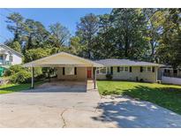 Ranch style home with carport and well-maintained lawn at 541 N Hairston Rd, Stone Mountain, GA 30083