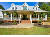 Two-story house featuring a wraparound porch and metal roof at 787 Tidwell Rd, Powder Springs, GA 30127