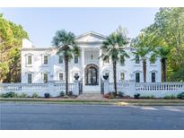 Stunning white mansion with palm trees and ornate gates at 3915 Muirfield Sq, Duluth, GA 30096