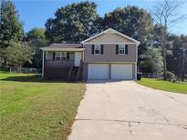 House exterior featuring two-car garage and a wooden deck at 2043 Laird Rd, Hiram, GA 30141