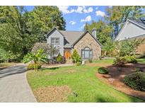 Gray house with stone accents, landscaping, and a paved driveway at 7445 Talbot, Sandy Springs, GA 30328