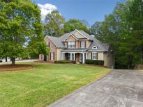 Two-story house with stone accents, a covered porch, and a landscaped lawn at 4930 Longridge Dr, Villa Rica, GA 30180