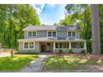 Two-story house with a covered porch and manicured lawn at 174 Rivertown Rd, Fairburn, GA 30213