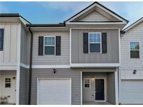 Two-story townhouse with gray siding, black shutters, and a white garage door, offering curb appeal at 5120 Lower Elm St, Atlanta, GA 30349