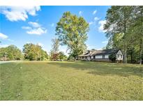 Ranch house with large yard, mature trees, and a brick facade at 1736 Pleasant Grove Rd, Temple, GA 30179