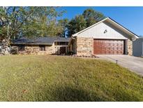 Stone and wood exterior, two-car garage, and nicely landscaped yard at 5934 S Deshon Ct, Lithonia, GA 30058
