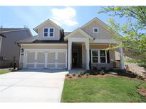 Two-story house with beige siding and a large garage at 5137 Aster Bnd, Canton, GA 30114