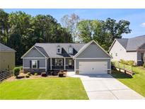 Gray house with stone accents, a two-car garage, and a well-manicured lawn at 1108 Red Bud Cir, Villa Rica, GA 30180