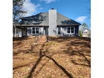 Rear view of a charming two-story house with gray siding, a brick staircase, and a spacious backyard at 20 Wisteria Blvd, Covington, GA 30016