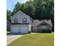 Two-story house with two-car garage and landscaped yard at 405 Pecan Wood, Fairburn, GA 30213