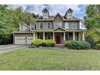 Two-story house with stone accents, a red door, and a landscaped lawn at 1720 Mountainside Dr, Cumming, GA 30040