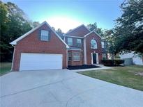 Brick house with a two-car garage and a large lawn at 7058 Shoals Way, Austell, GA 30168