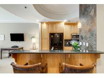 Kitchen with an island and breakfast bar, wood cabinets and granite countertop at 2255 Peachtree Rd # 328, Atlanta, GA 30309