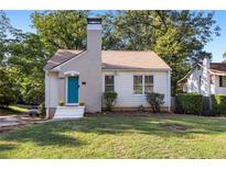 Charming single story home with teal door and manicured lawn at 1880 Vesta Ave, Atlanta, GA 30337