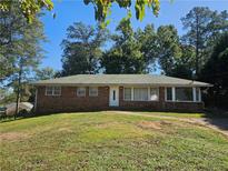 Brick ranch house with a green roof and grassy yard at 3801 Orchard Se Rd, Smyrna, GA 30080