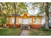 Charming yellow house with a front porch and steps at 418 N Highland Ne Ave, Atlanta, GA 30307