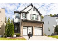 Two-story brick home with a three-car garage and landscaped yard at 5570 Crestwick Way, Cumming, GA 30040