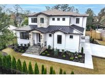 Two-story modern home with metal roof, stone accents, and landscaped lawn at 1413 Windsor Ne Pkwy, Brookhaven, GA 30319