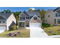 Two-story brick home with a two-car garage and landscaped lawn at 1898 Lacebark Elm Way, Lawrenceville, GA 30045