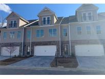 Three-unit townhome building with modern design, two-car garages, and attractive landscaping at 2140 Manor Pointe Dr, Cumming, GA 30041