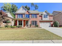 Brick house with a two-car garage and landscaping at 3191 Lake Mcginnis Dr, Suwanee, GA 30024