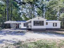 Charming white house with gray accents and a covered carport, nestled among lush greenery at 198 Oak Hill Cir, Canton, GA 30114