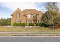 Two story brick home with landscaping and driveway at 1896 Alcovy Bluff Way, Lawrenceville, GA 30045
