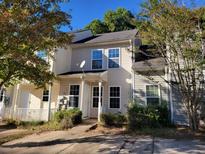 Beige townhouse with a satellite dish and small yard at 6348 Wellington Walk Way, Lithonia, GA 30058