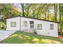 Charming ranch home with a white exterior, deck, and landscaped yard at 2396 Abner Nw Pl, Atlanta, GA 30318