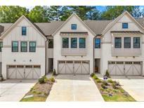 Three-unit townhome building with neutral siding and garages at 118 Briargate Dr, Johns Creek, GA 30097