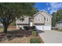 Two-story house with stone accents, attached garage, and mature tree at 4072 Staghorn Ct, Douglasville, GA 30135
