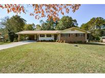 Ranch house with brick and siding exterior, covered carport, and lawn at 4250 Crabapple Trl, Austell, GA 30106