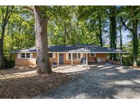 Brick ranch house with a carport and mature trees at 422 White Oak Nw Dr, Lilburn, GA 30047