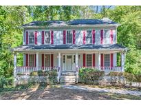 Two-story house with white siding, red shutters, and a wraparound porch at 2459 Jacks View Ct, Snellville, GA 30078