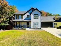 Two-story home with white siding, black accents, and a well-manicured lawn at 430 Thornbush Trce, Lawrenceville, GA 30046