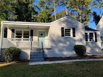 Charming ranch home with light-colored brick, black shutters, and a covered porch at 411 Greencove Se Ln, Atlanta, GA 30316