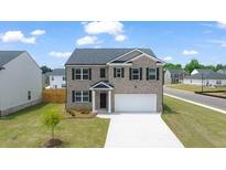 Two-story brick home with a two-car garage and landscaped yard at 619 Whitman (2200) Ln, Stockbridge, GA 30281
