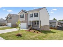 Two-story brick home with a charming front yard and attached garage at 576 Whitman (2020) Ln, Stockbridge, GA 30281