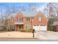 Brick house with a two-car garage and manicured lawn at 2865 Payton Oaks Ne Dr, Atlanta, GA 30345