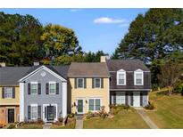 Three-unit townhouse building with gray and yellow siding at 3971 Wolcott Cir # 3971, Atlanta, GA 30340