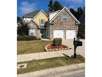 Beautiful two-story home with a brick and siding exterior, two-car garage, and landscaped lawn at 165 Summit Point Dr, Fayetteville, GA 30214