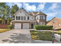 Two-story brick home with a two car garage and well-manicured lawn at 5401 Stone Cove Sw Dr, Atlanta, GA 30331